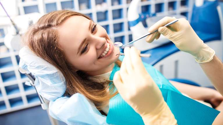 A woman sits comfortably on a dental chair